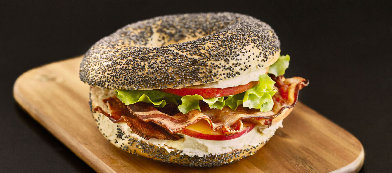 Mohnbagel belegt mit Bacon, Frischkäse und Apfel
