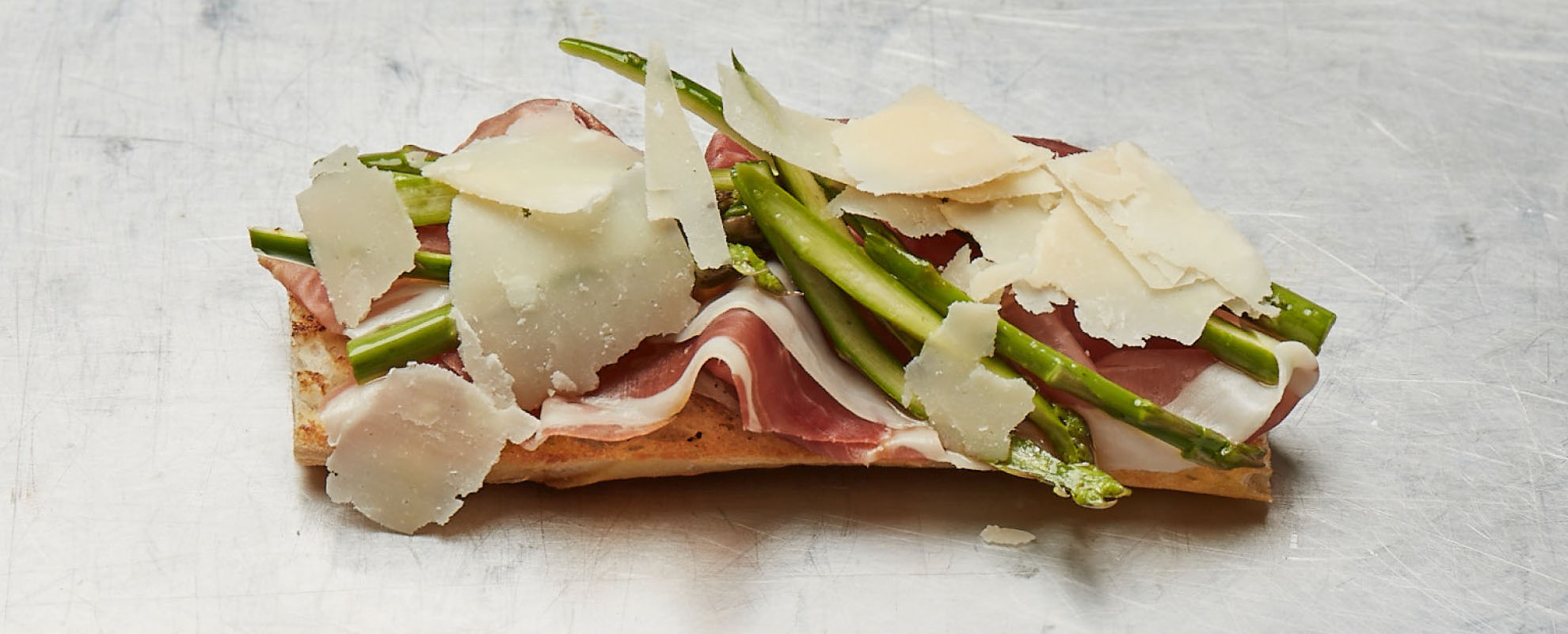 Belegtes Baguette mit grünem Spargel, Fiocco Parmaschinken und Parmesanspänen