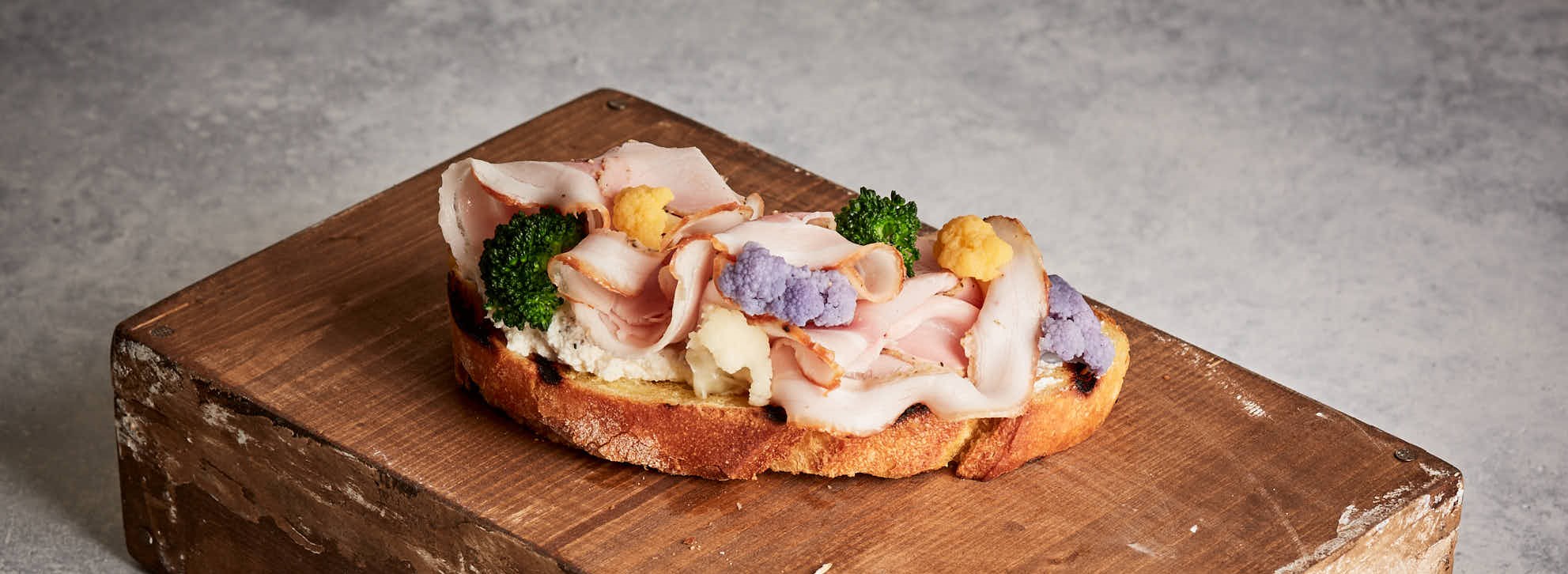 Crostone con porchetta arrosto alle erbe, ricotta e composizione di cavolfiori