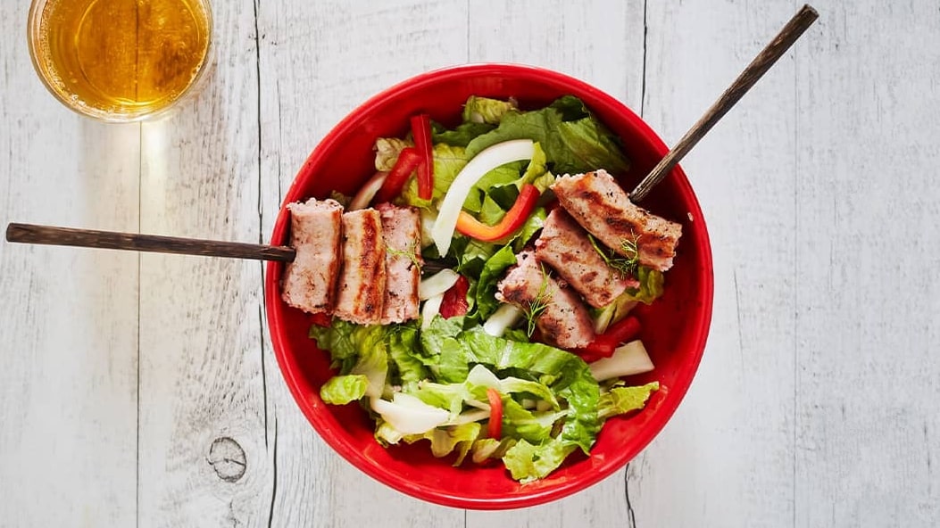 Salade avec poivrons, fenouil et brochettes de saucisses grillées