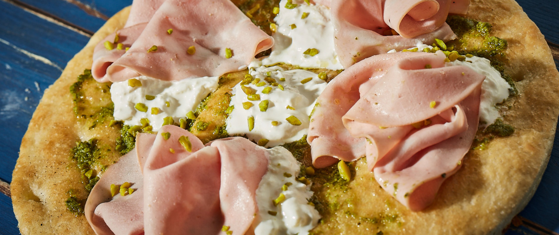 Pizza avec Mortadella, stracciatella de burrata et pesto de pistaches
