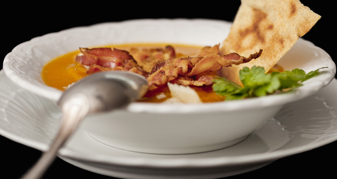 Squash soup with crispy bacon and parmesan cheese