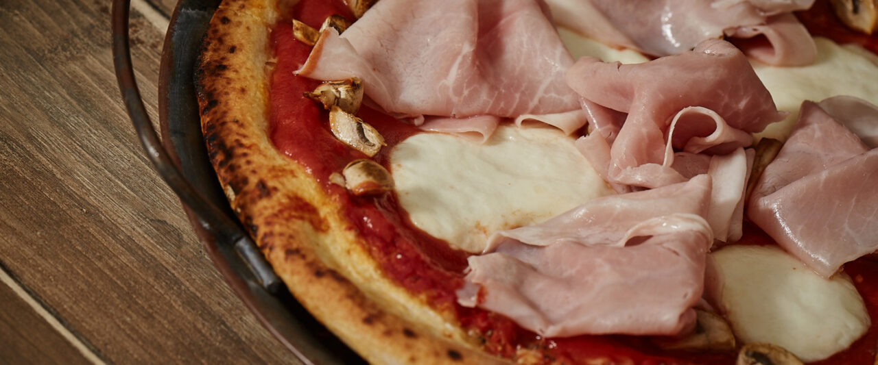 Pizza mit gekochtem Schinken, Tomatenpüree, Champignons und Fiordilatte ...
