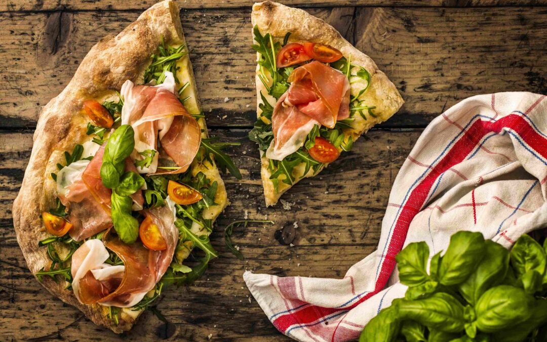 Pizza with cured ham, rocket and cherry tomatoes